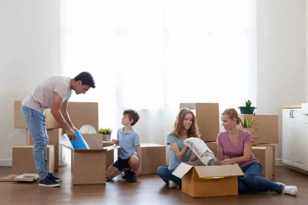 A family packs boxes with towels and other necessities