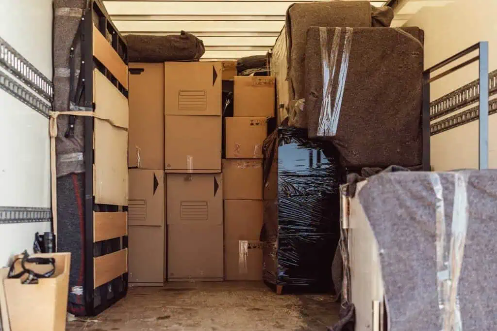 An example of a packed truck where moving blankets are used as both wrapping for furniture and cushion in the spaces between boxes