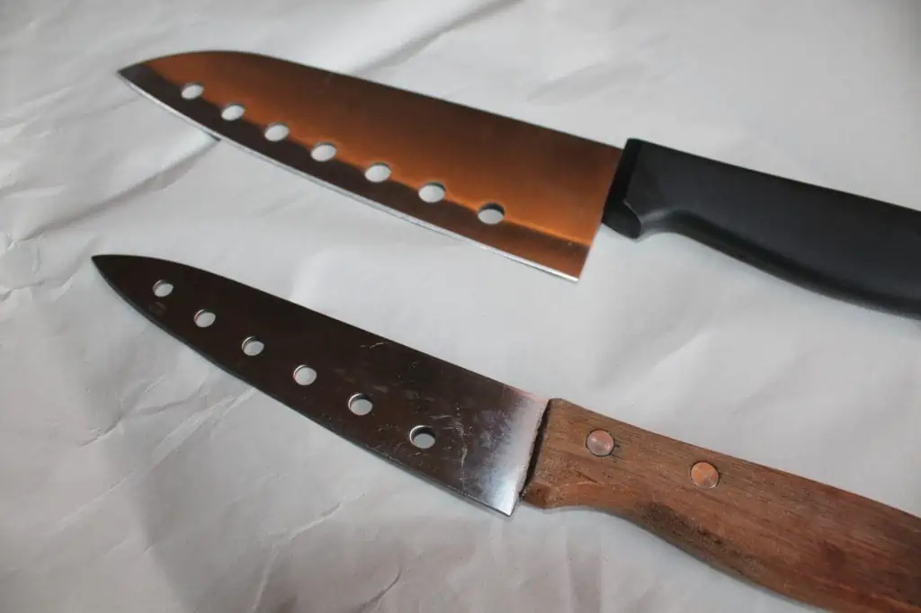 two knives set side by side but around two inches apart on a sheet of packing paper