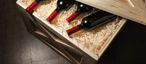 an image of wine settled on top of packing material in a wooden wine crate