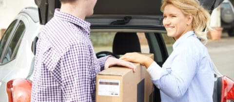 a couple packs a TV into their car in the upright position to prevent damage