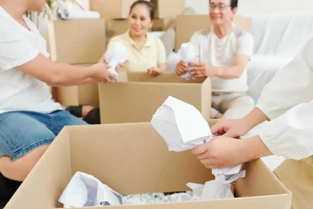 a family packs wrapped wineglasses into a box