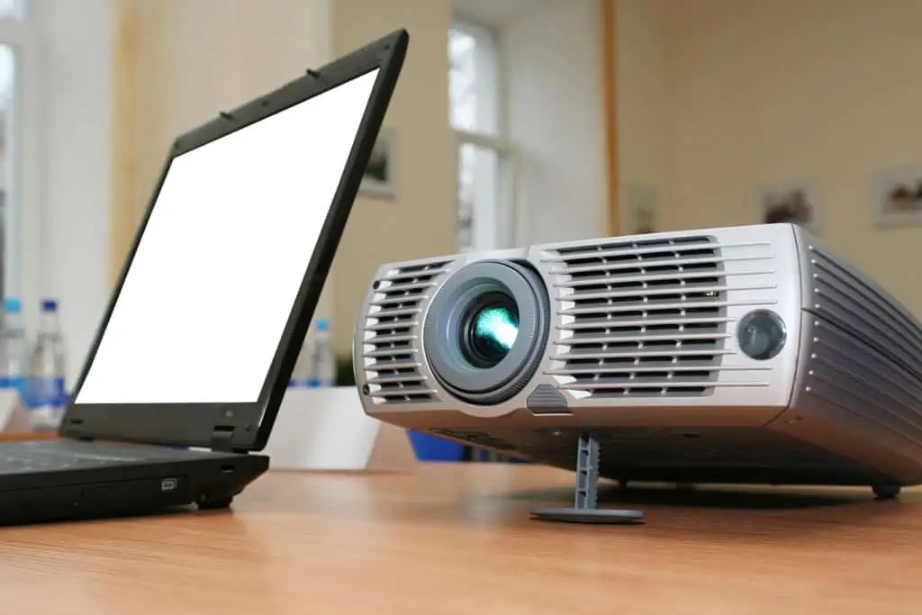 a laptop and a projector sit on a table