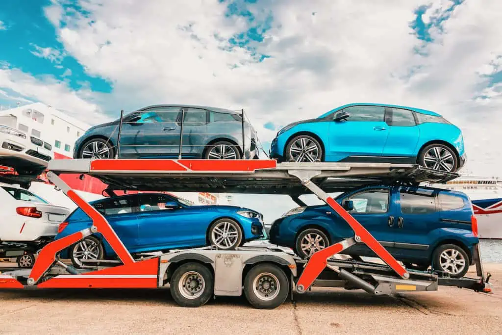 an open air car transporter sits in a lot