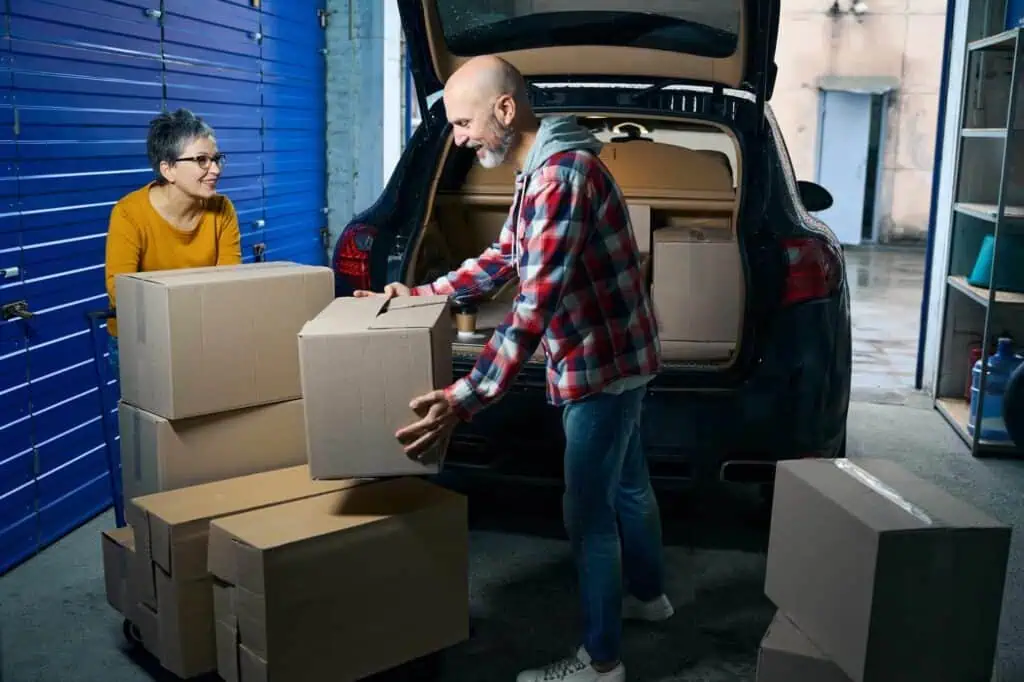 An older couple packs up their car in preparation for a move