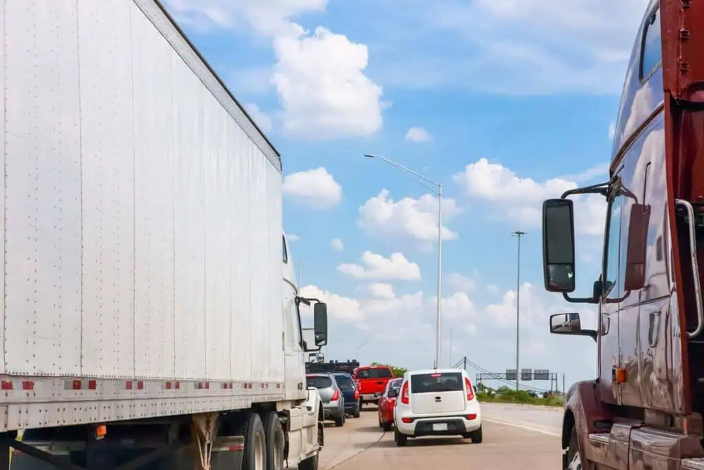 Trucks and several other cars are stuck in bumper to bumper traffic