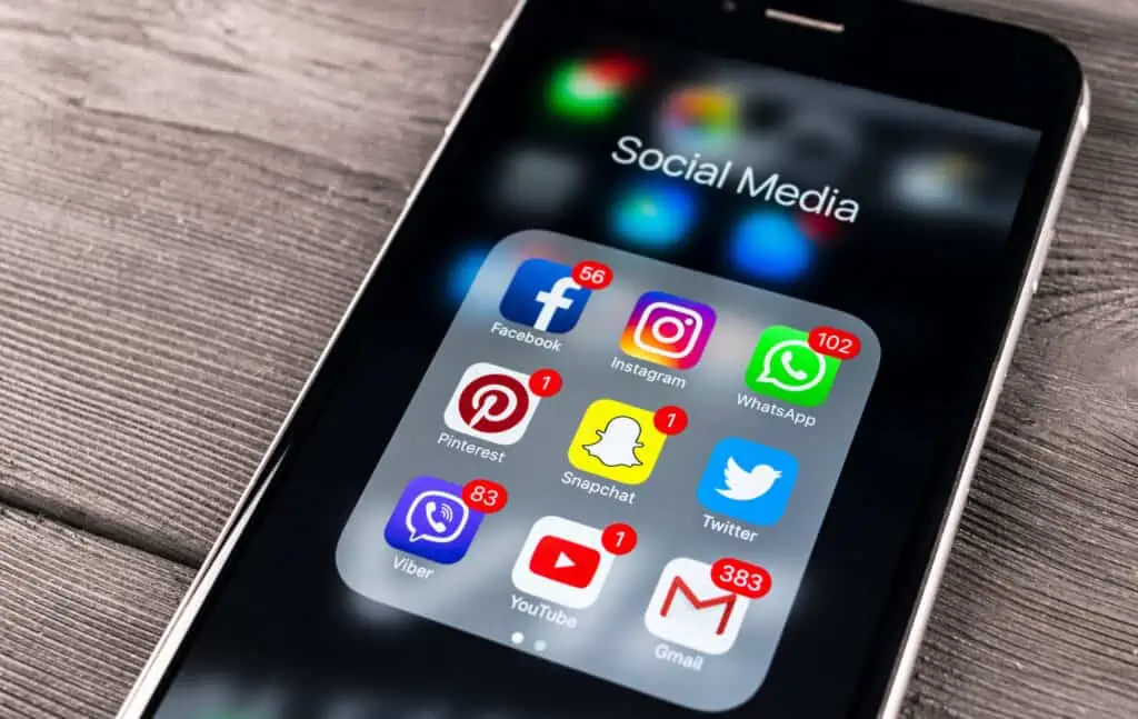 an iphone7 screen with many social media apps, including facebook, twitter, and instagram. Using these apps and platforms can help improve your digital presence