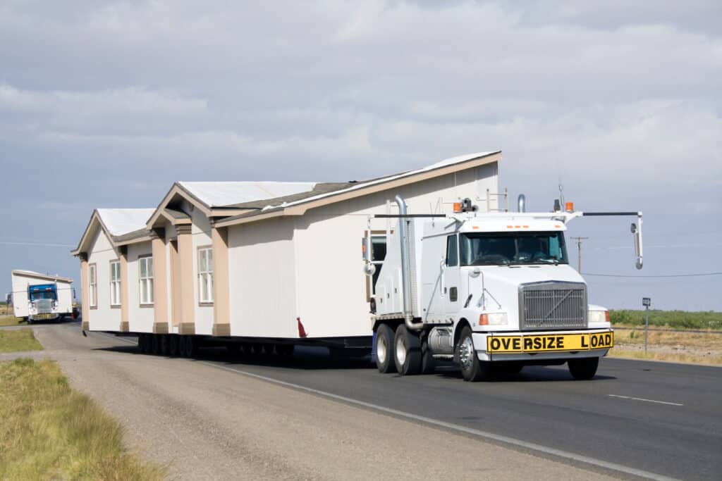 a white truck transporting a mobile home