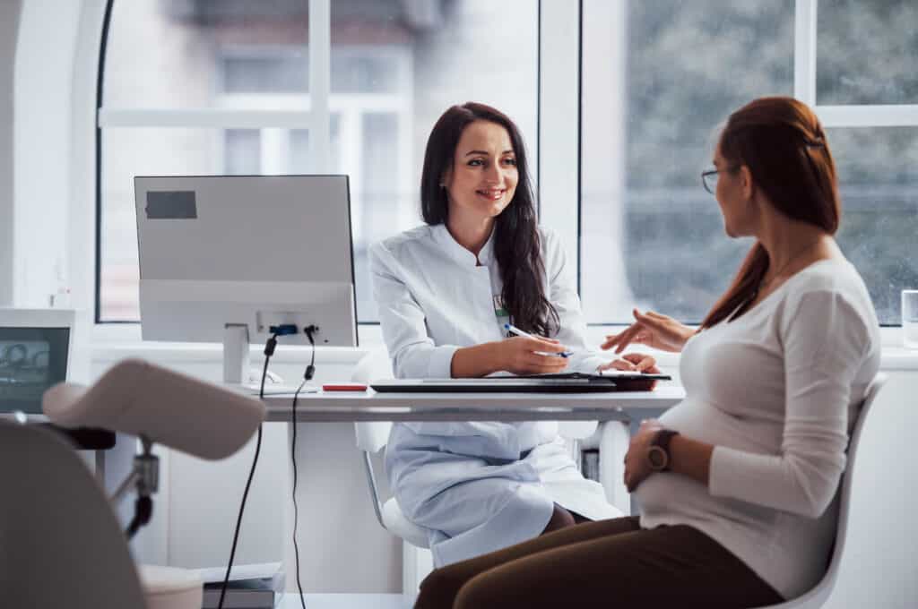 a pregnant person speaks to a physician