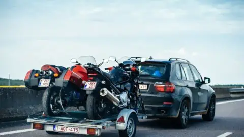 an ev tows a trailer with motorcycles on the back