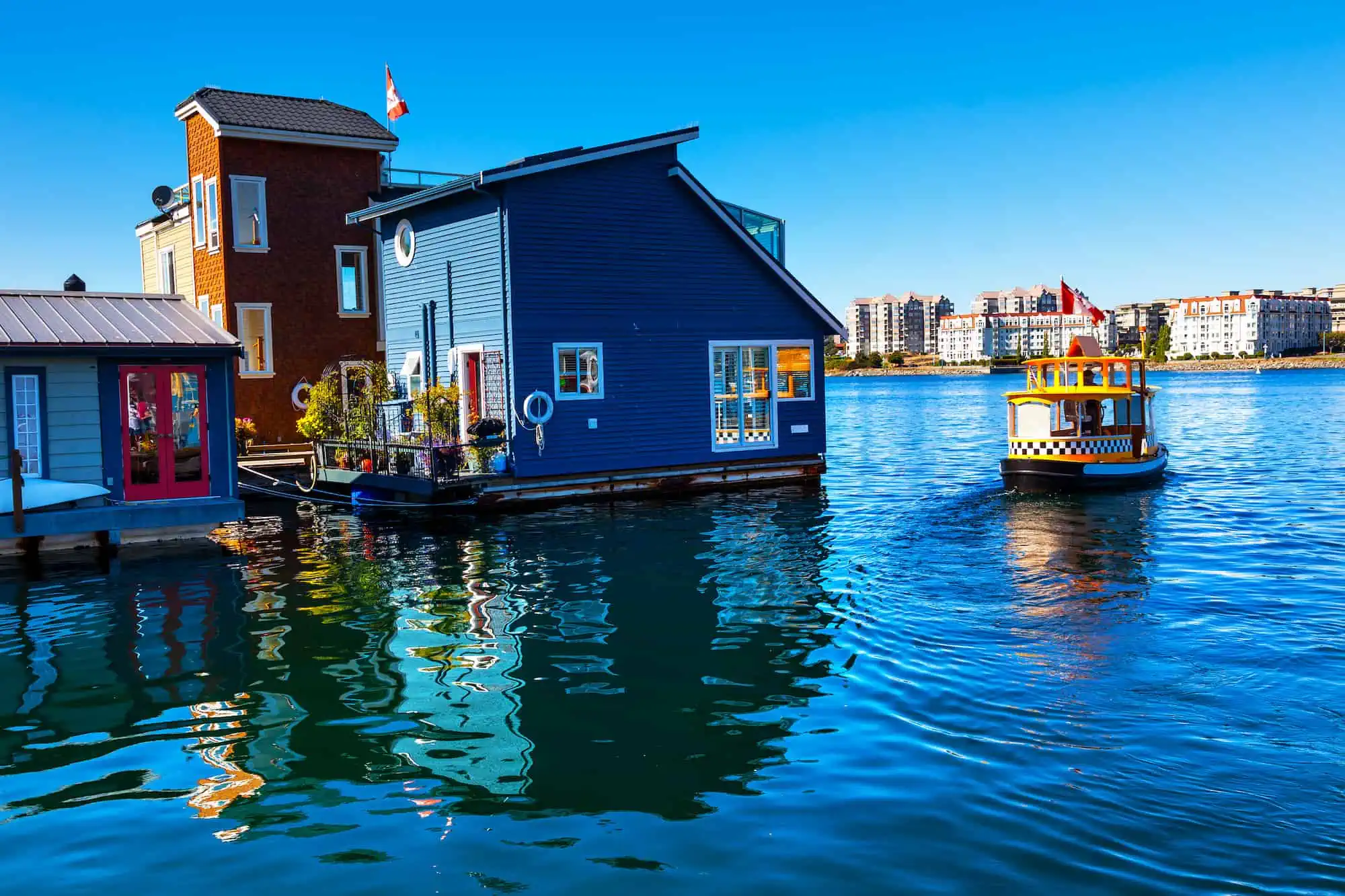 a boat taxi drives by a floating home neighborhood