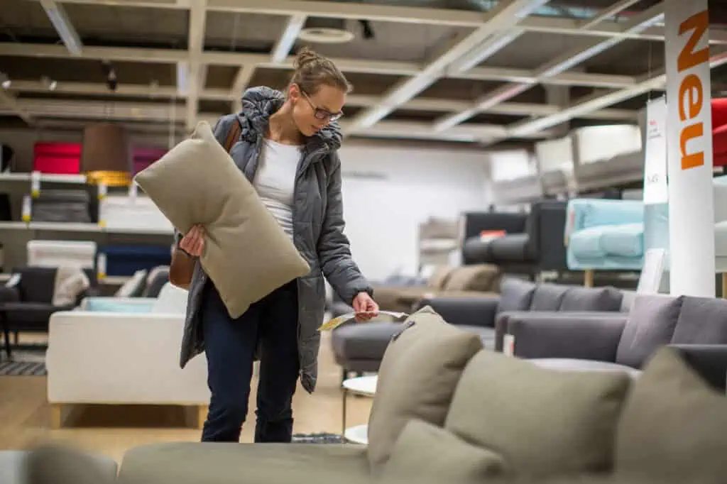 a woman looks at the price of an olive green couch