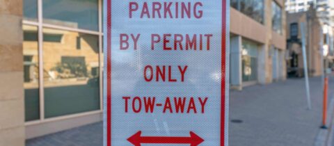 a red and white sign that says the area is only for parking with a permit