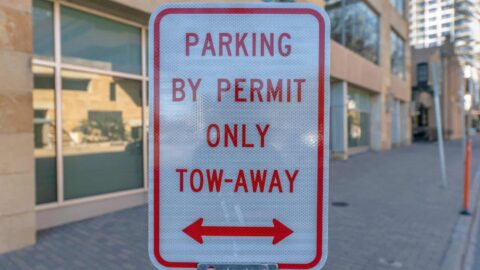 a red and white sign that says the area is only for parking with a permit