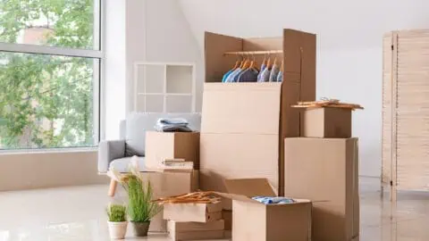 moving boxes of different sizes and types are stacked in the middle of a room