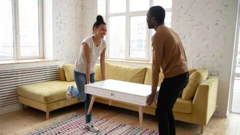 a couple moves furniture around to rightsize their living room