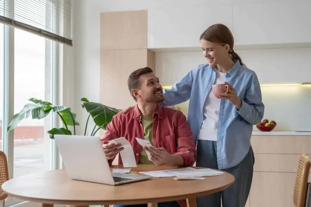 A couple looks at receipts in front of a computer as they do their taxes