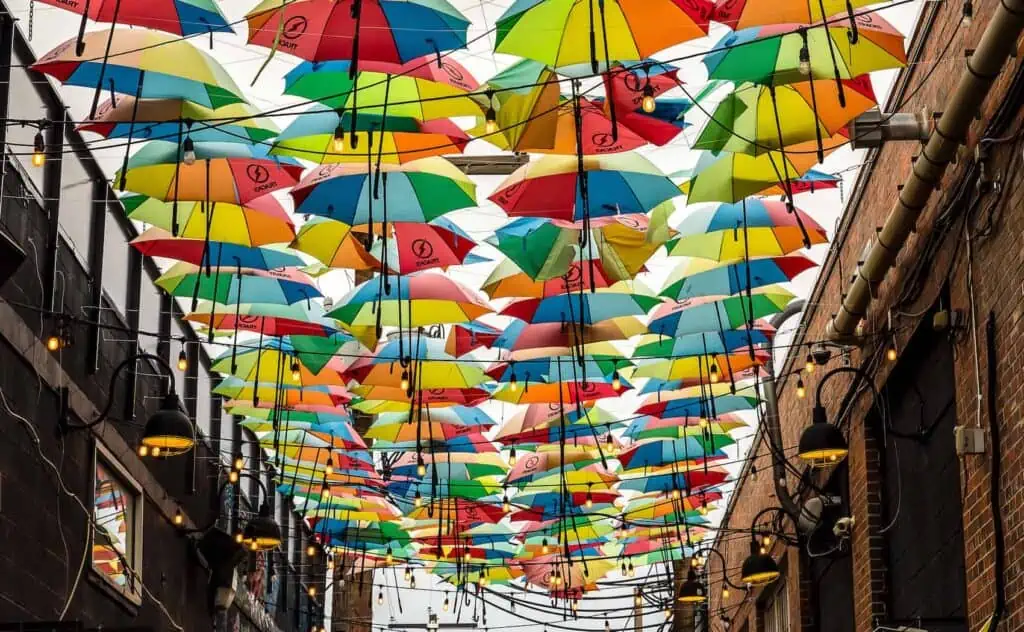an art installation made up of colorful umbrellas strung along an alley in denver's river north neighborhood.