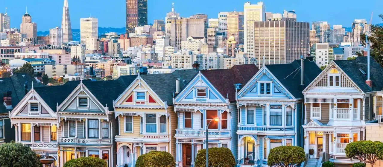 a evening view of the Painted Ladies homes in San Francisco. The downtown skyline can be seen in the background