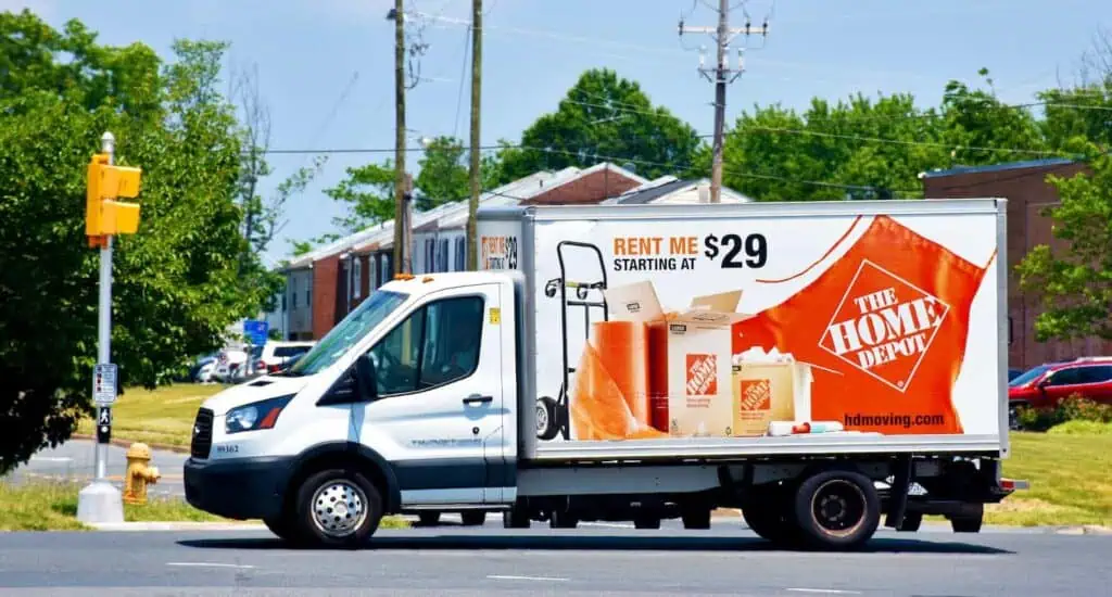 A home depot box truck driving along a residential road