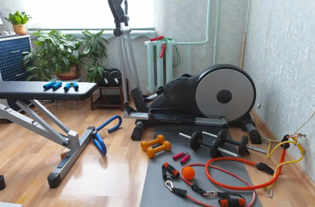 A home gym with a stationary bike, weights, resistance bands, and a yoga mat