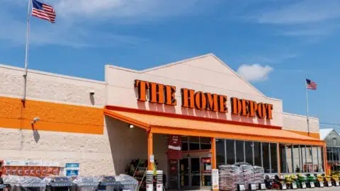 the front facade of a home depot. Product displays and the entrance can be seen.