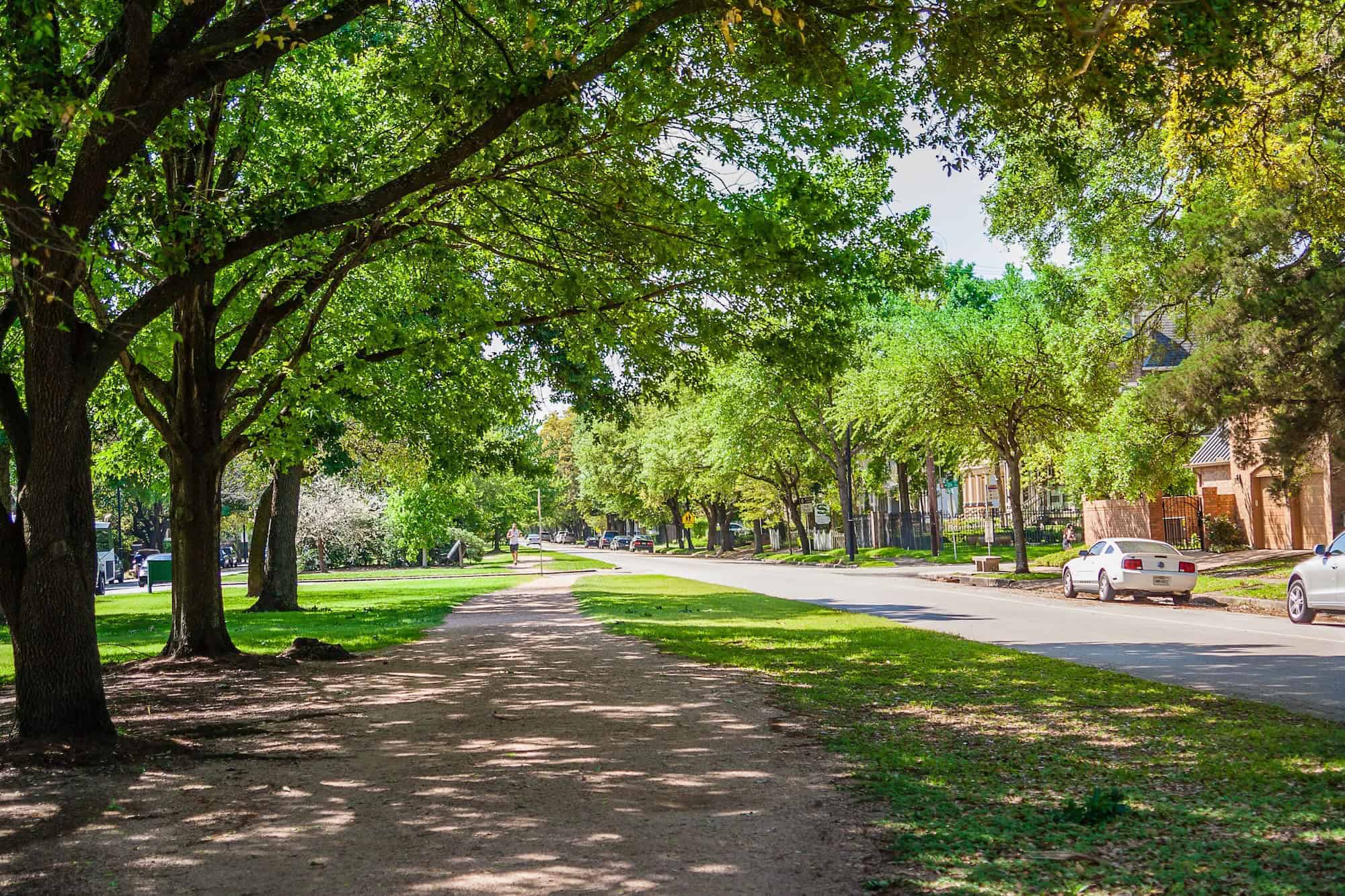A shaded running path beside a residential street in The Heights neighborhood