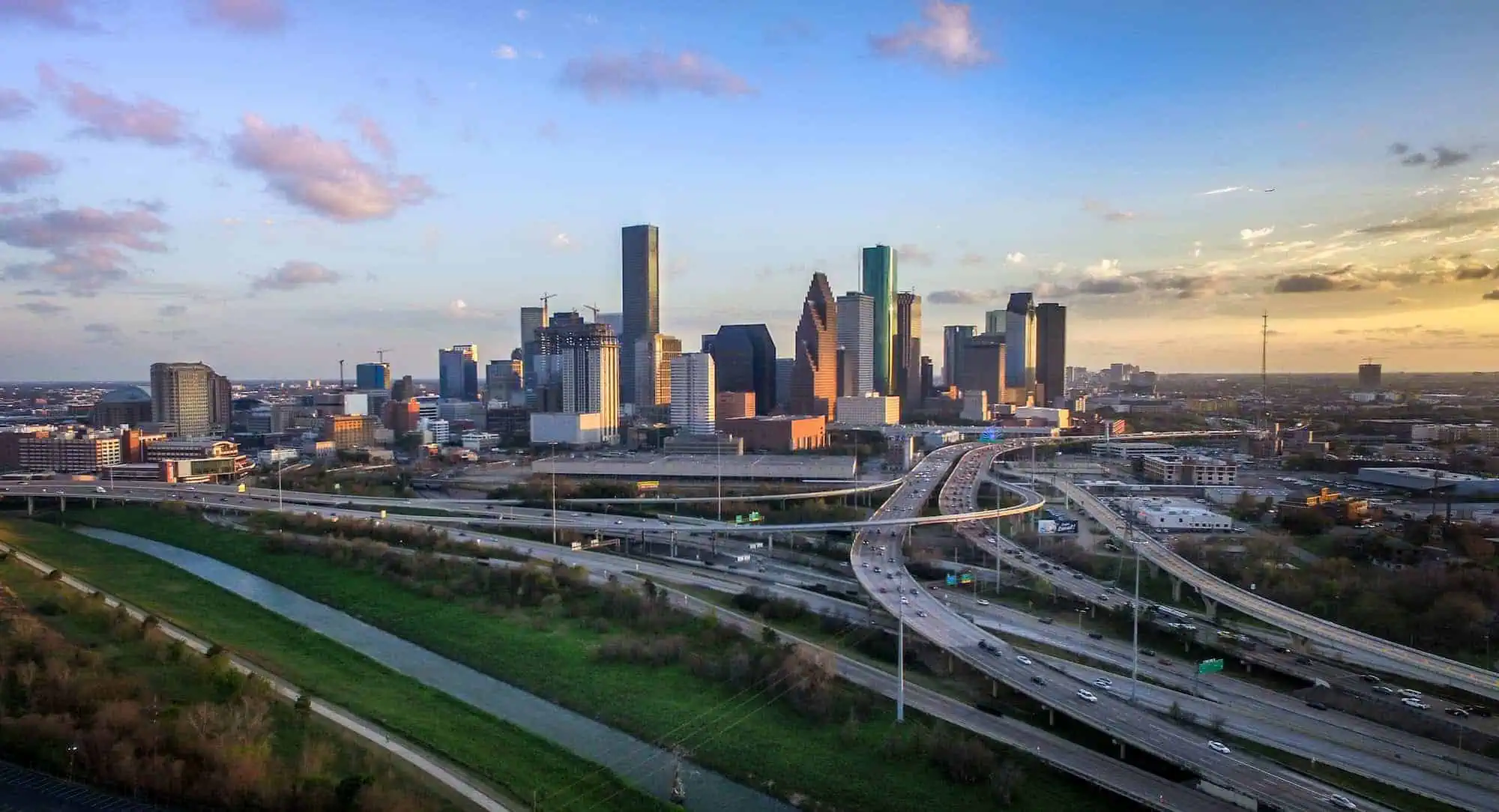 A view of Houston, TX's skyline behind the freeways and highways that lead into and out of the city