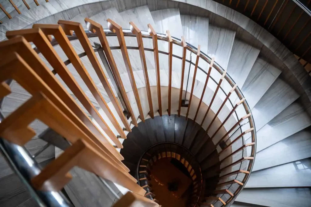 a top-down view of a winding staircase with wooden railing