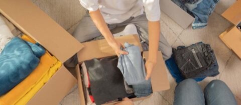 An arial shot of people packing clothing into various moving boxes