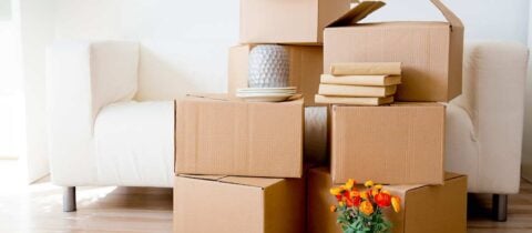 Moving boxes stacked in front of a white couch