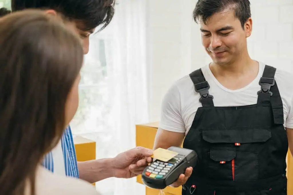 A couple pays movers with a card and portable payment divice