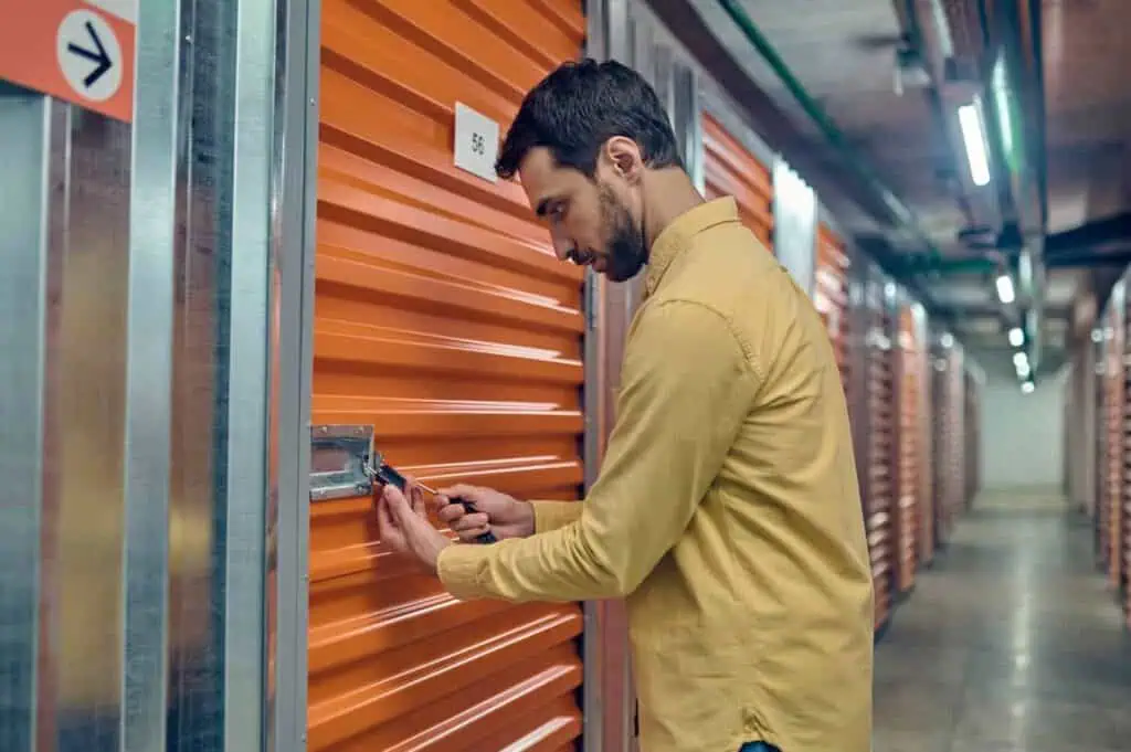 A man uses a key to unlock his storage unit