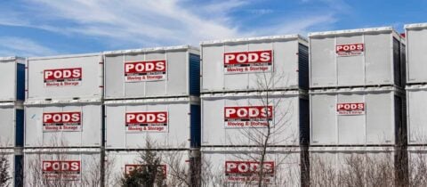 Many PODS containers are stacked on top of each other at a storage facility