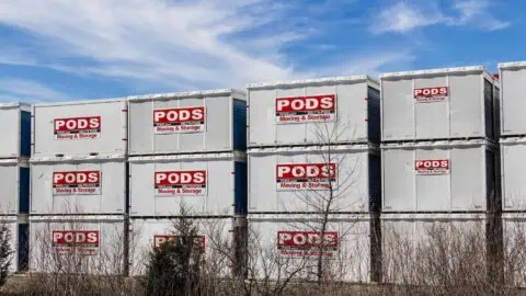 Many PODS containers are stacked on top of each other at a storage facility