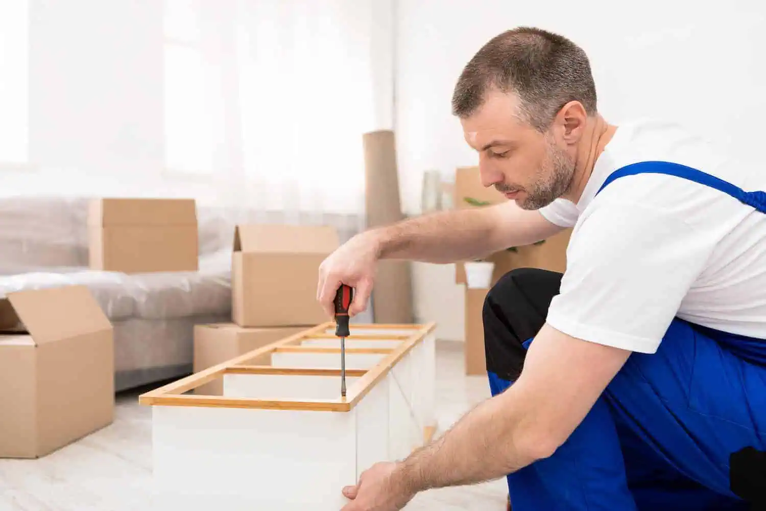 A man works to disassemble a shelving unit
