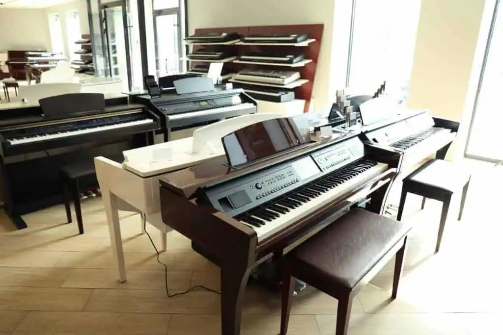 several pianos of different types sit in a store