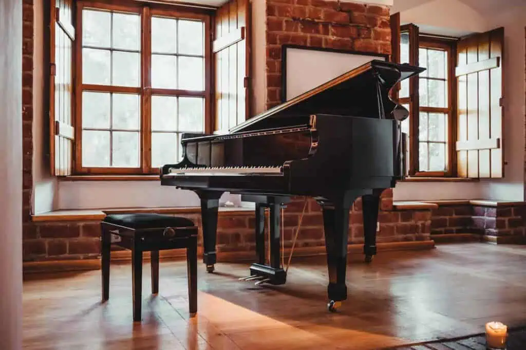 A grand piano sits in the middle of a wide room