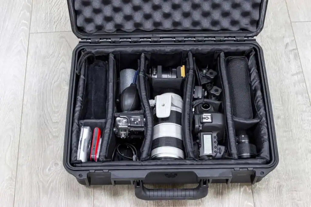 Open camera case with organized photography equipment and lenses.