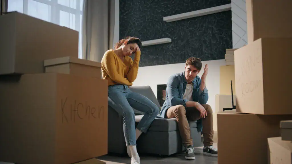 A couple sitting at home among moving boxes