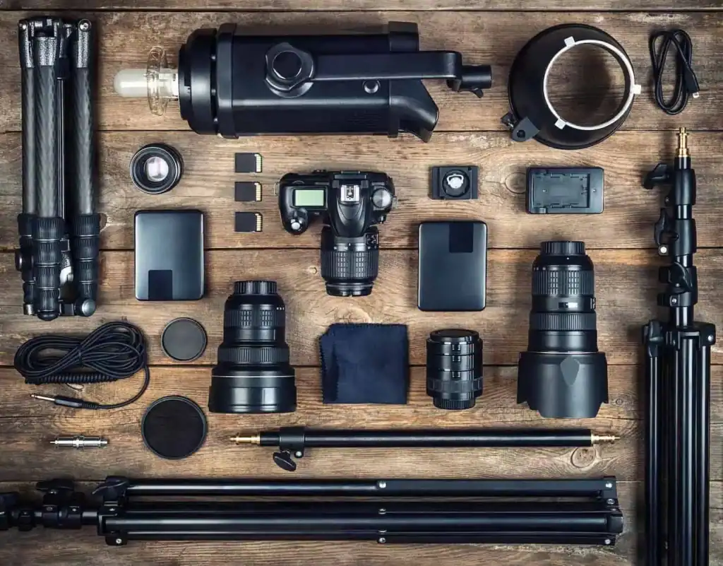 Flat lay of photography equipment including cameras, lenses, and tripods.