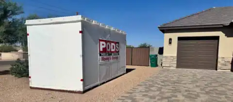 A PODS moving and storage container placed in a residential driveway