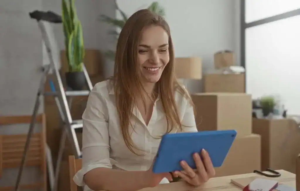 Woman reviewing a moving checklist surrounded by packed boxes