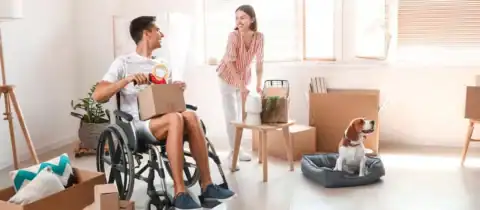 Couple packing moving boxes in accessible home