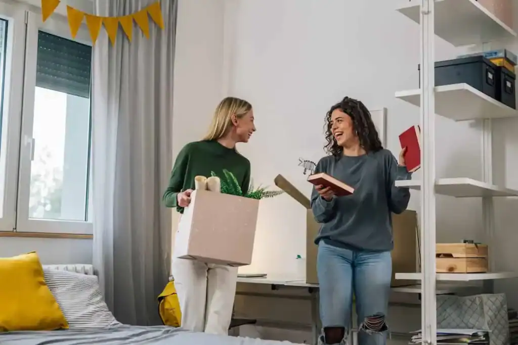Friends smiling while packing moving boxes together