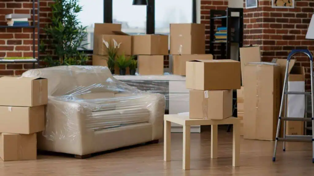 Several boxes and furniture sit in an empty room waiting to be moved