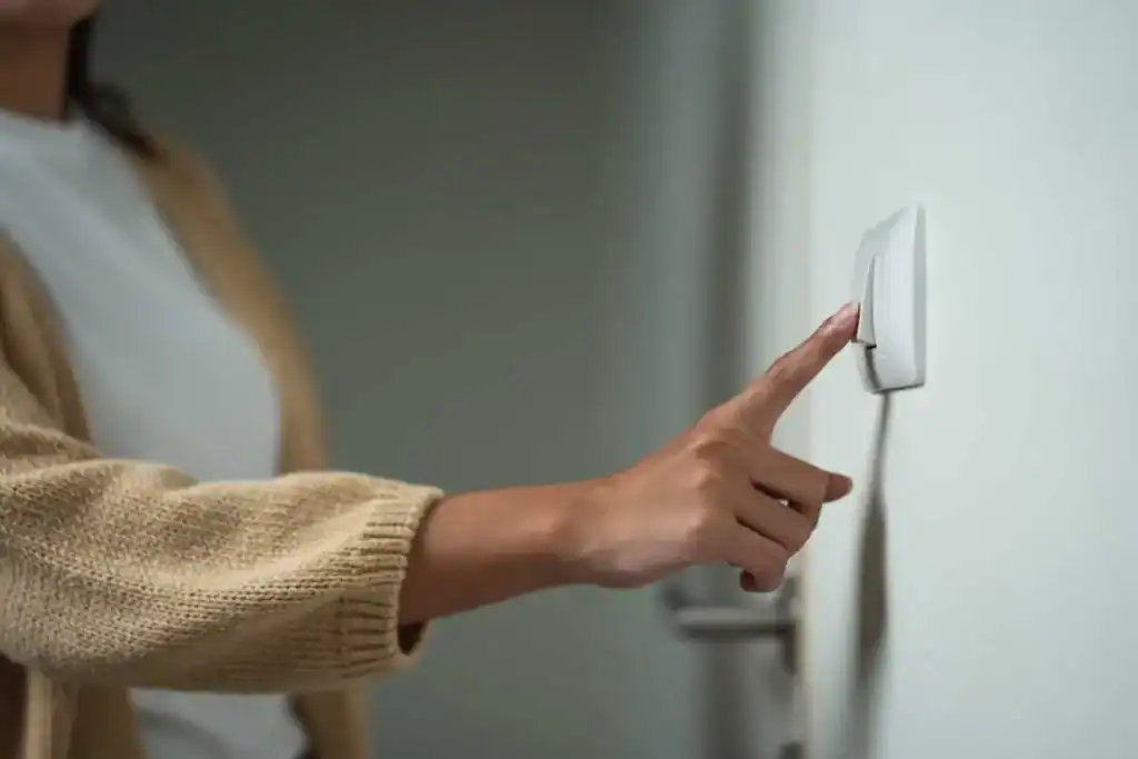 A woman turning on a light switch