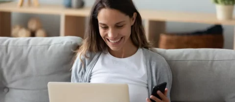 woman smiling with laptop and phone