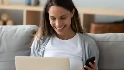 woman smiling with laptop and phone