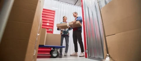 Couple organizing moving boxes inside a self-storage unit